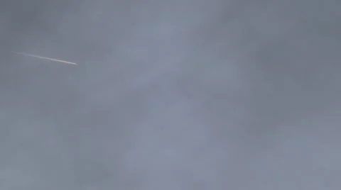 Pink-ish comet-style jet contrail flyover with bright reflection Video stock 47995649