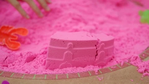 Pink kinetic sand that forms a building Stock Footage 245623980