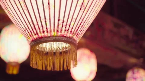 A pink  lantern with flower patterns on hung on a roof of a temple. Stock Footage 140266440