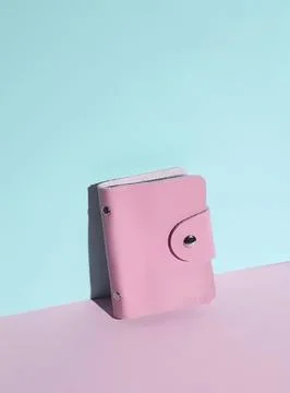 Pink leather wallet with button closure on pastel background Stock Photos