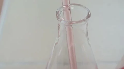 Pink liquid being poured into a test tube through a chemical pipette in a Stock Footage 231030876