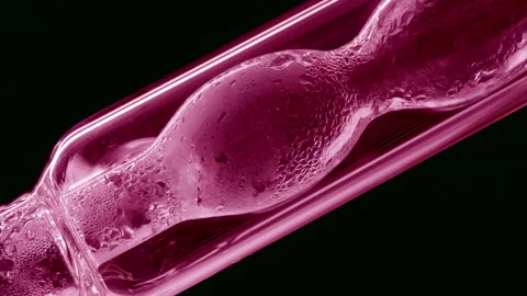 Pink liquid condensing on bulb lab condenser black background Stock Footage 337759640