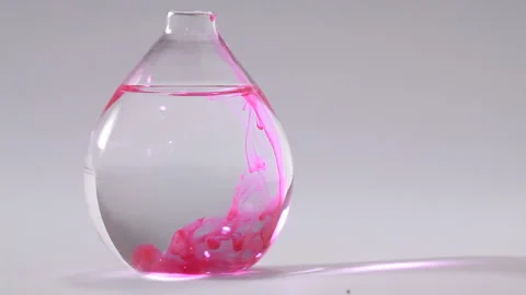 Pink liquid going down throughout water on a flat bottomed flask Stock Footage 231488212