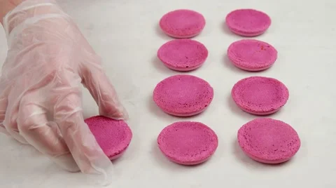 Pink Macaron shells on baking sheet, preparing for filling Stock Footage 62425986