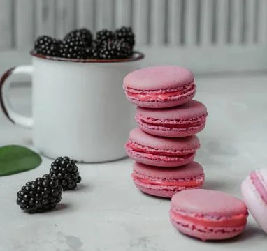 Pink macarons with blueberries on the table Stock Photos