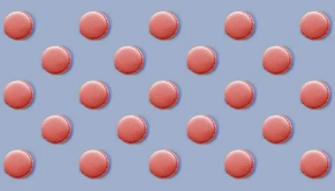 Pink macaroons scattered in different direction on blue background, flat lay Stock Photos