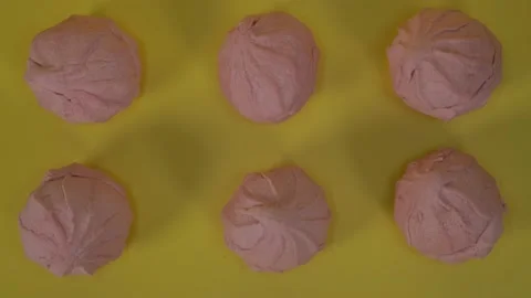 Pink marshmallow on a yellow background. Blinking light Stock Footage 134444623