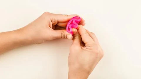 Pink Menstrual Cup folded with a E-Fold Method Stock Photos