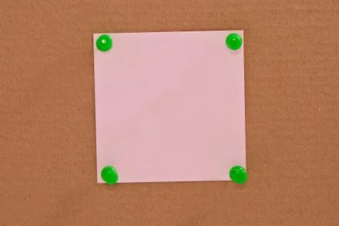 Pink note paper attached with green pin 스톡 사진