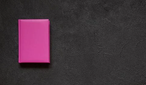 Pink notepad on a black concrete background. Top view. Stock Photos