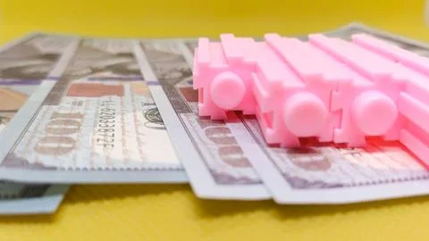Pink Objects on Dollar Bills Representing Financial Concept in Bright Backg.. Stock Photos