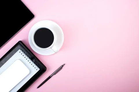 Pink office table with computer, pen and a cup of coffee, lot of things. Top  Stock Photos