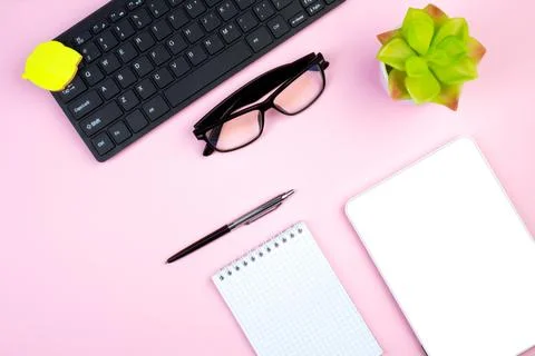 Pink office table with computer, pen and a cup of coffee, lot of things. Top  Stock Photos