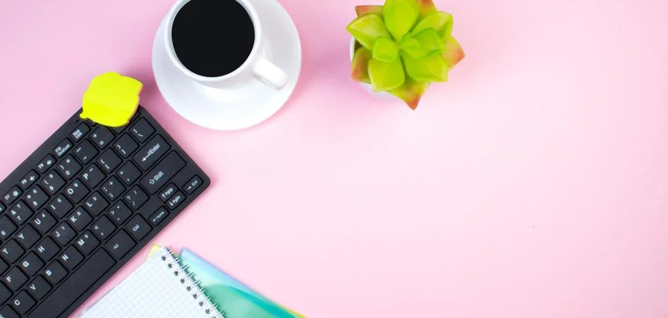 Pink office table with computer, pen and a cup of coffee, lot of things. To.. Stock Photos