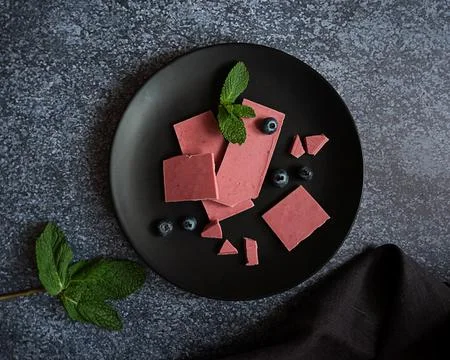 Pink or ruby chocolate, trendy dessert on a black plate on dark backround Stock Photos