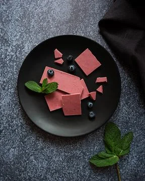 Pink or ruby chocolate, trendy dessert on a black plate on dark backround Stock Photos