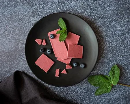 Pink or ruby chocolate, trendy dessert on a black plate on dark backround Stock Photos