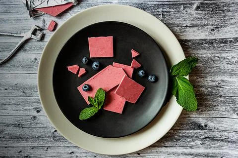 Pink or ruby chocolate, trendy dessert on a black plate on wooden grey backround Stock Photos