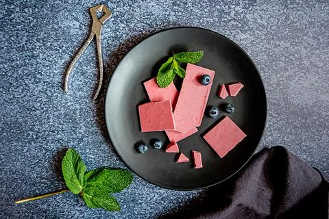 Pink or ruby chocolate, trendy dessert on a black plate on dark backround Stock Photos