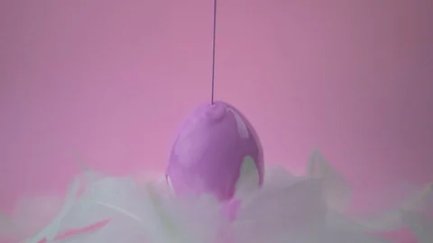Pink paint slowly pours onto an Easter egg. Stock Footage 122321545