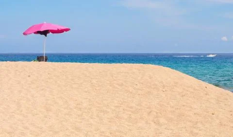 Pink parasol on a beach Stock Photos