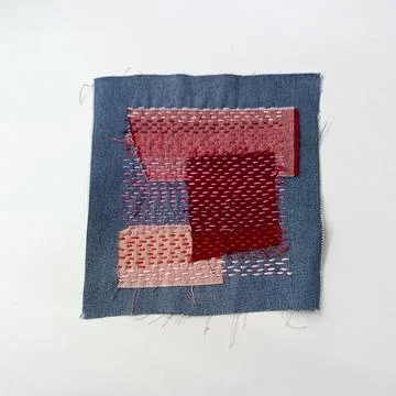 Pink Patchwork Embroidery Composition on Denim Fabric Background Fotos de archivo