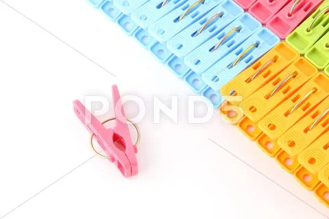 Pink peg in front of pegs row from upper on white background. Stock Photos