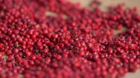 Pink peppercorns placed on a kitchen table. Rotation. Falling. Extreme macro of Stock Footage 126134263