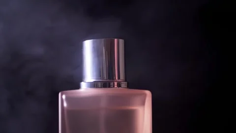 Pink Perfume Bottle With Silver Cap In Swirling Smoke On Dark Background Vídeo Stock 330110284
