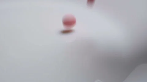 Pink pills fall down on white background in slow motion Video stock 98125746