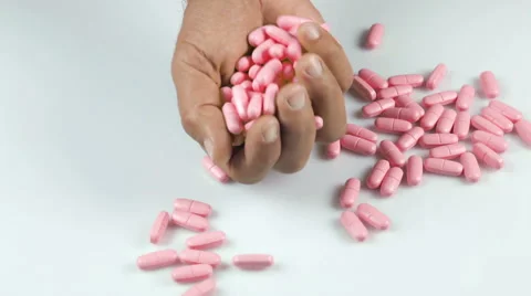 Pink pills falling into an open hand Vidéo 41853796