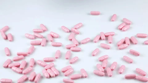 Pink pills falling on the table Stock Footage 41853777