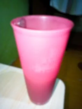 Pink plastic cup from the side, defocused 스톡 사진