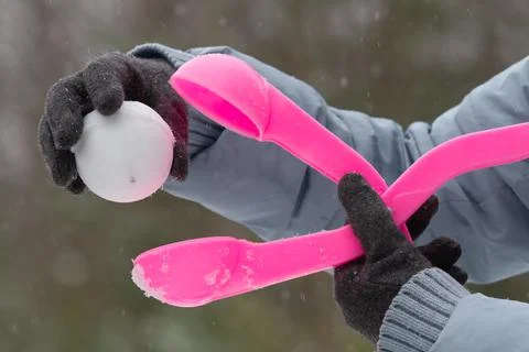 Pink plastic form for making a snowball in hands Stock Photos