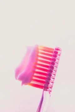 Pink plastic toothbrush with a white toothpaste on an isolated background. 스톡 사진