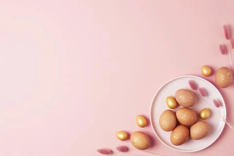 Pink plate with easter eggs and flowers on pink background. Flat lay, copy .. Stock Photos