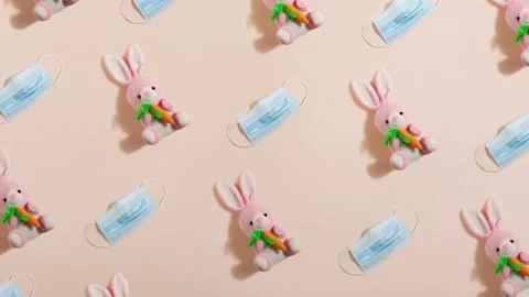 Pink plush little Easter bunny with a ginger carrot with blue medical mask. Stock Footage 149123648