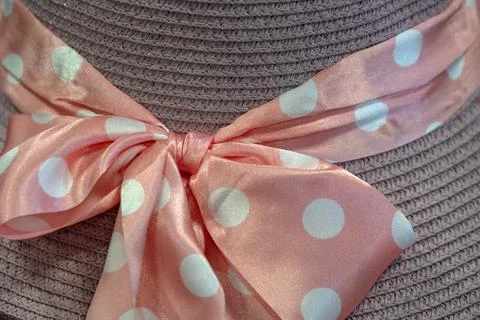 Pink polk dot bow and ribbon on straw hat Stock Photos