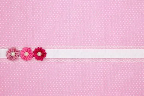 Pink polka dot textile background with ribbon and flowers Stock Photos