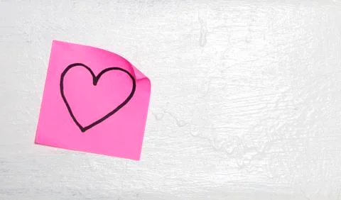 Pink post-it on the wall with drawn heart Stock Photos