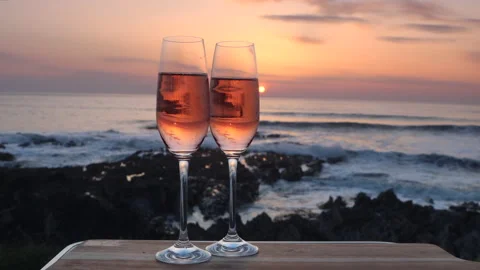 Pink Prosecco in glasses backlit by sunset at Woolacombe Beach Stock Footage 172356765