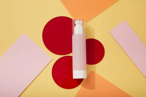 Pink pump bottle with transparent cap placed on some round acrylic sheets in  스톡 사진