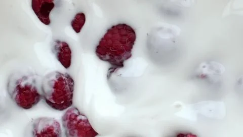 Pink raspberry floating dessert closeup. Summer berries milk yoghurt breakfast Stock Photos