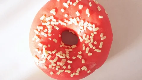 Pink, red donut, doughnut rotating, turning round, view from above, flat lay Stock Footage 124123539