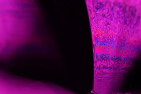 Pink reflections of liquid in macro, red surface 写真素材