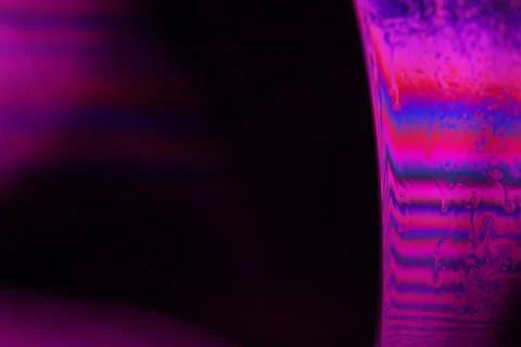 Pink reflections of liquid in macro, red surface Stock Photos