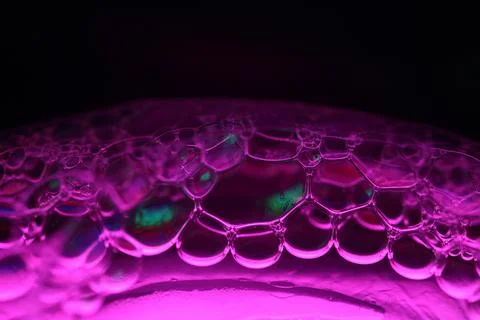 Pink reflections of liquid in macro, red surface Stock Photos
