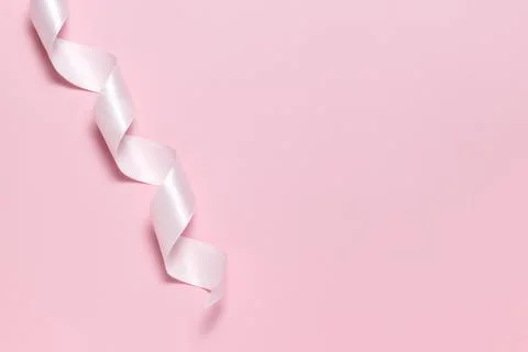 Pink ribbon for gift wrapping on a solid pink background Stock Photos