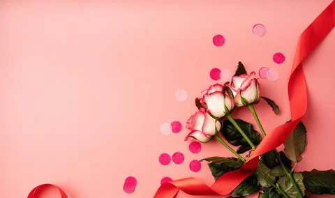 Pink roses with confetti on solid pink background 写真素材