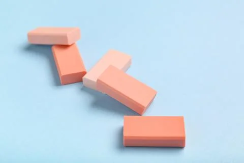 Pink rubber erasers on blue background, closeup 库存照片